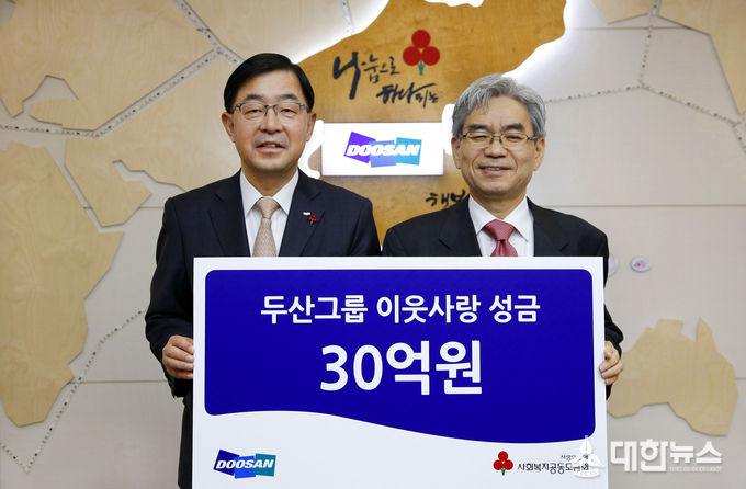 박완석 ㈜두산 부사장(왼쪽)이 박찬봉 사회복지공동모금회 사무총장에게 성금을 전달하고 있다.