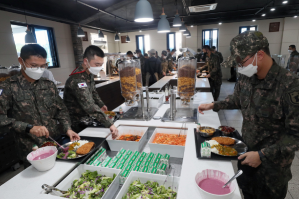 육군이 추진하는 ‘더 좋은 병영식당’ 시범운영 부대인 육군 32보병사단 장병들이 점심 메뉴인 돈가스, 쫄면, 카레, 소시지 등을 식판에 옮겨 담고 있다.(국방일보 제공)